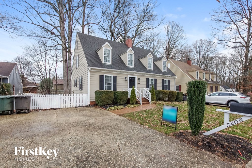 A house with a white picket fence and a sign that says "FirstKey Homes".