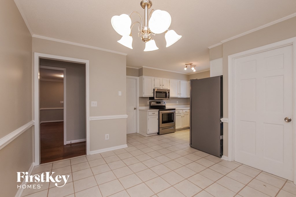 A kitchen with a refrigerator, oven, and microwave.