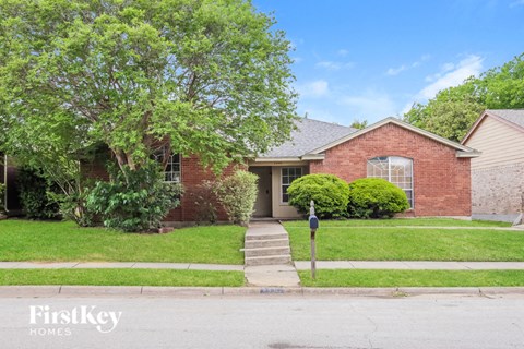 a brick house with a yard and a parking meter