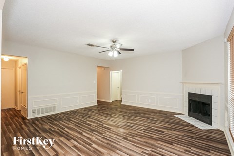 a living room with a fireplace and a ceiling fan
