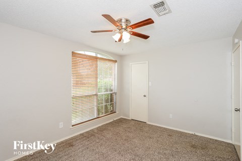 a bedroom with a ceiling fan and a window