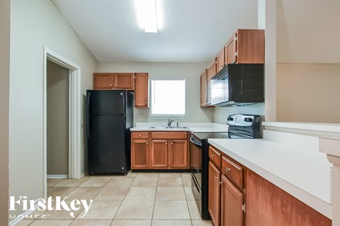 A kitchen with wooden cabinets and black appliances.