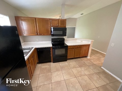 A kitchen with a black fridge, black oven and black microwave.