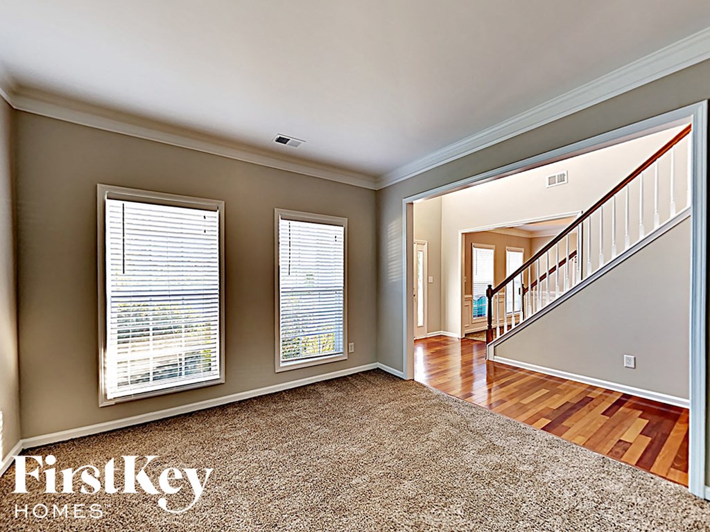 A spacious room with a staircase leading to another room.