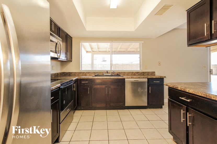 a kitchen with black cabinets and stainless steel appliances