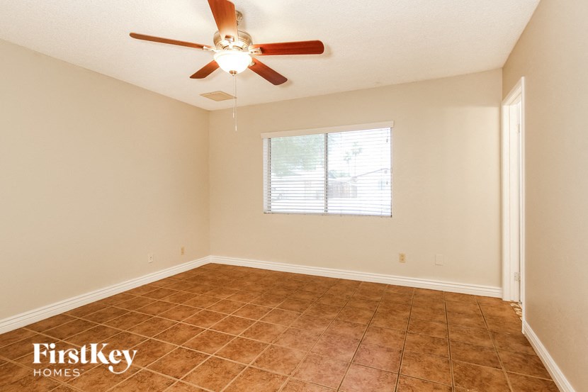 an empty room with a ceiling fan and a window