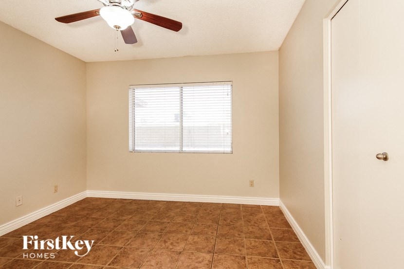 a empty room with a ceiling fan and a window