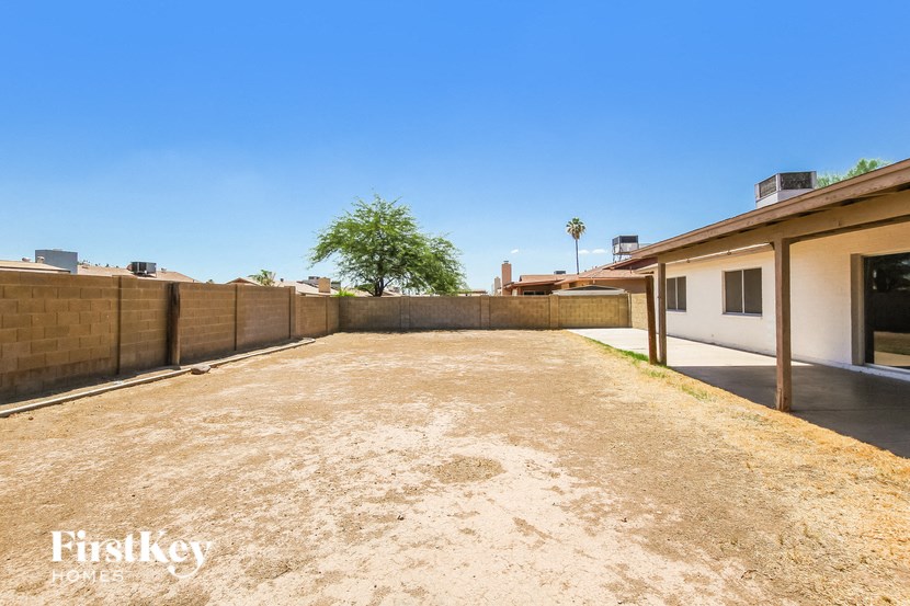 a large yard with a fence and a house