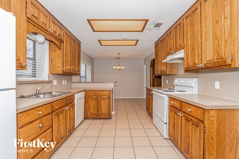 A kitchen with wooden cabinets and white appliances.