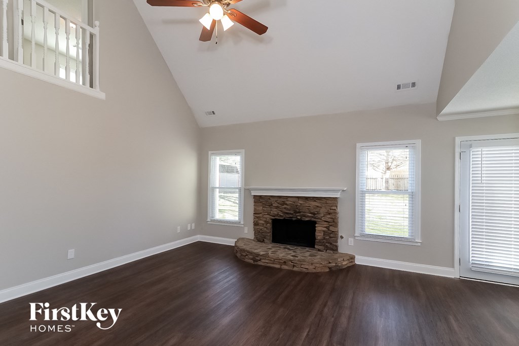 a living room with a fireplace and a ceiling fan