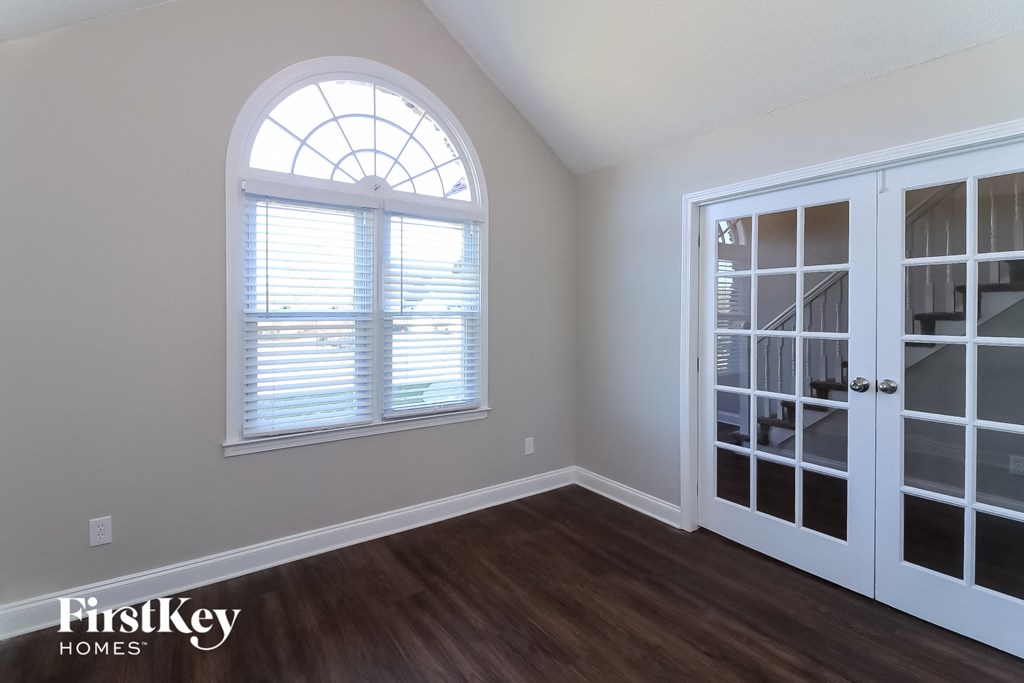 the living room of a house with a window and doors