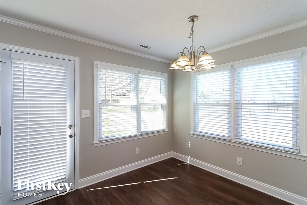 a dining room with a chandelier and three windows