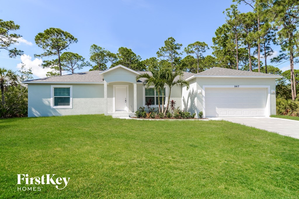 a white house with a lawn in front of it