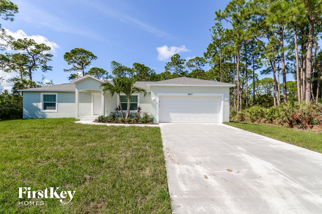 a white house with a driveway and a garage door