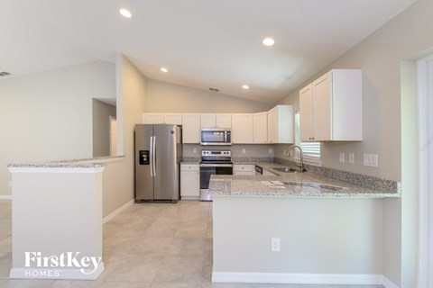 a kitchen with white cabinets and stainless steel appliances and granite counter tops