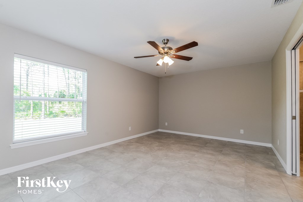 an empty room with a ceiling fan and a window