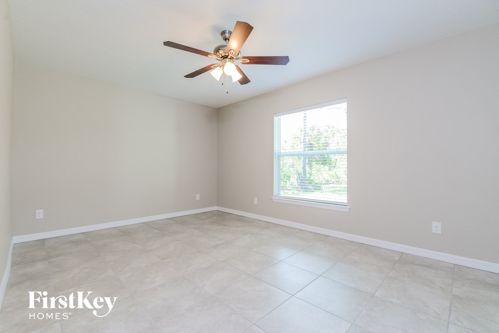 a clean and empty living room with a ceiling fan