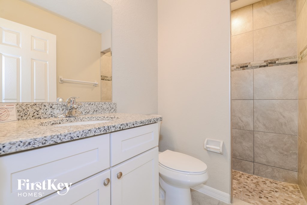 a bathroom with a toilet and a sink and a shower
