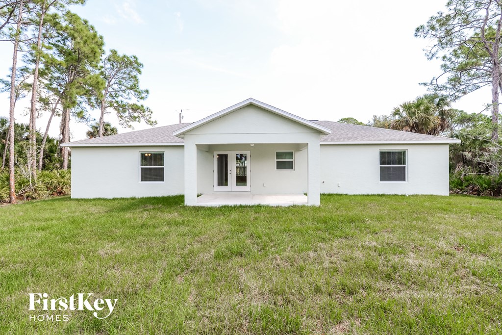 a white house with a lawn and trees