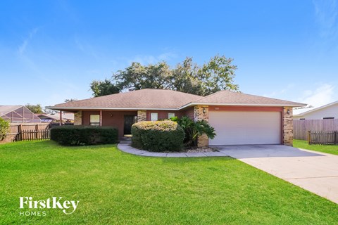 A house with a brown roof and a white garage door is for sale.