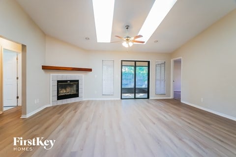 A spacious living room with a fireplace and sliding glass doors.