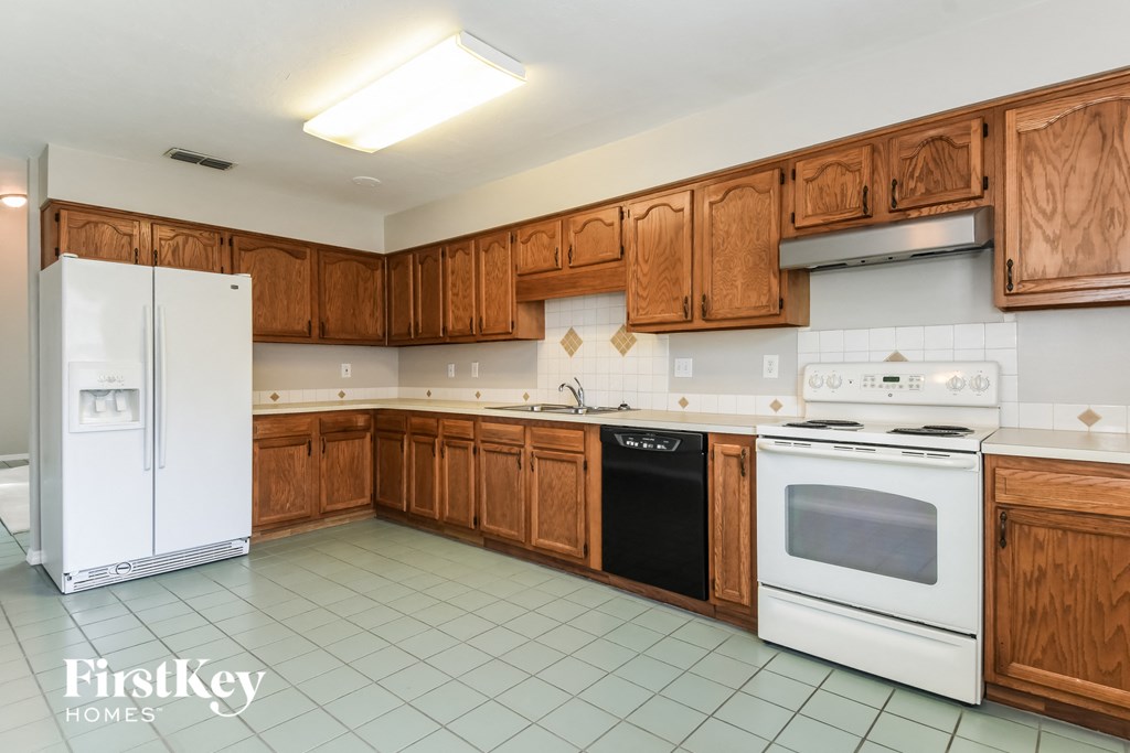 a kitchen with white appliances and wooden cabinets