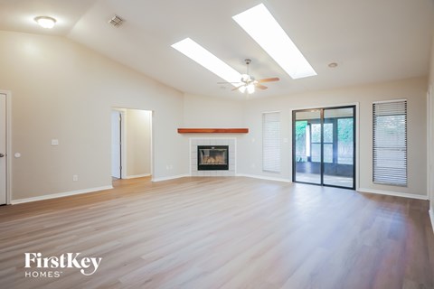 A spacious room with a fireplace and sliding glass doors.