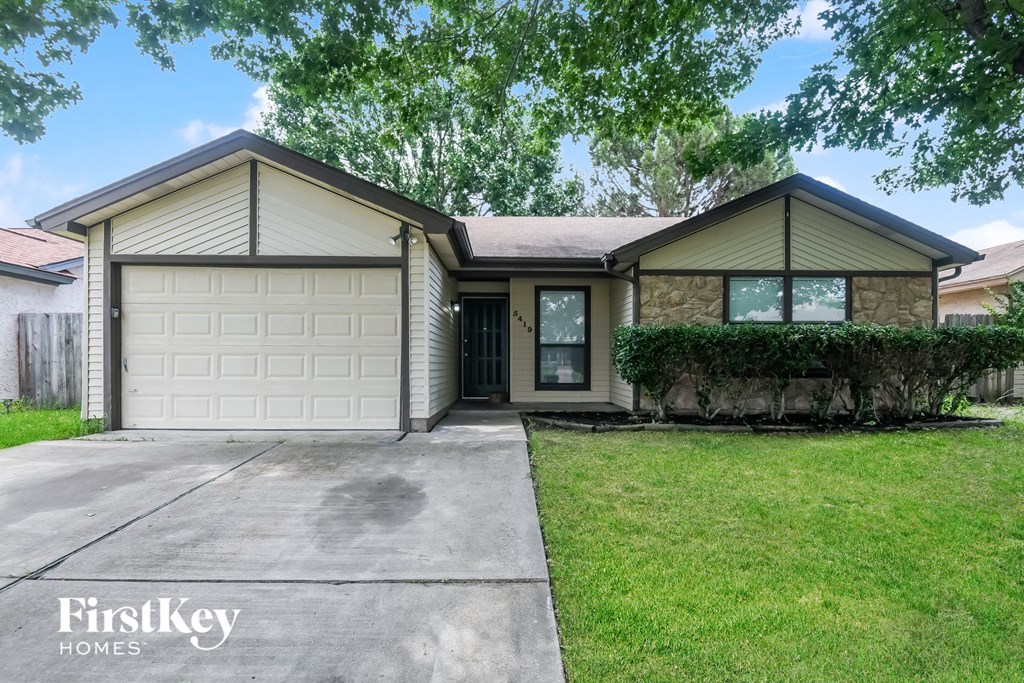 a home with a white garage door and a lawn