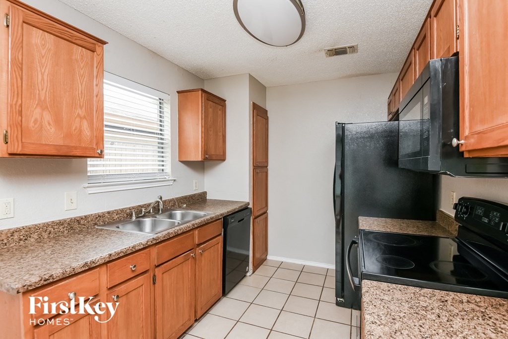 a kitchen with black appliances and granite counter tops