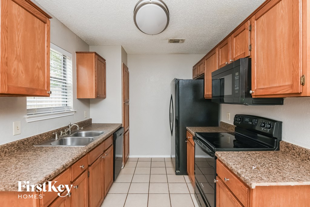a kitchen with granite counter tops and black appliances