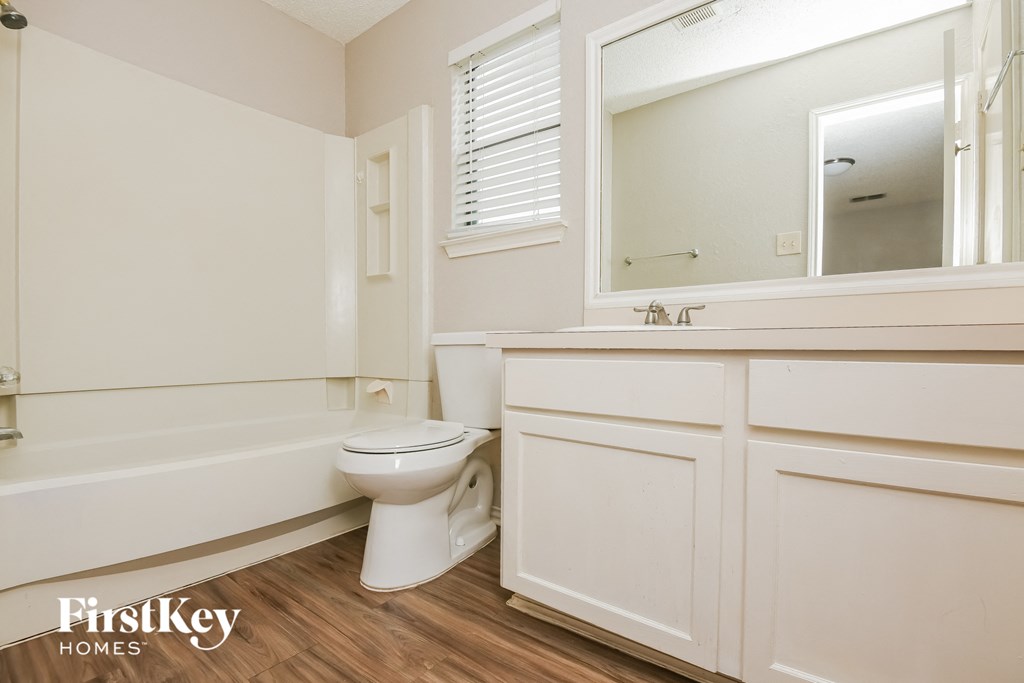 a bathroom with a toilet and a sink and a bath tub