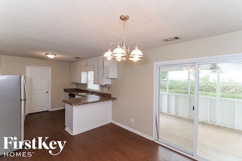A kitchen with a refrigerator, cabinets, and a countertop.