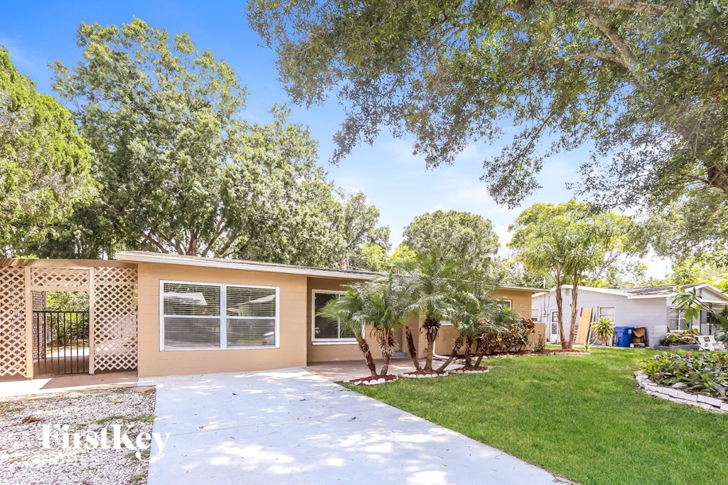 A house with a driveway and trees in the background.