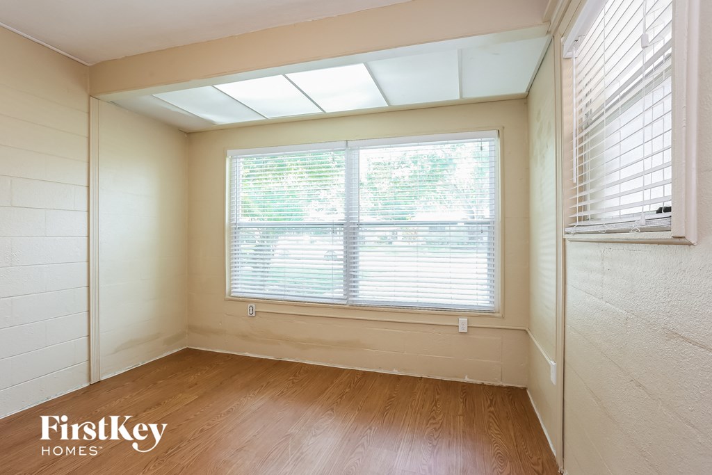 A room with a window and wooden floors.