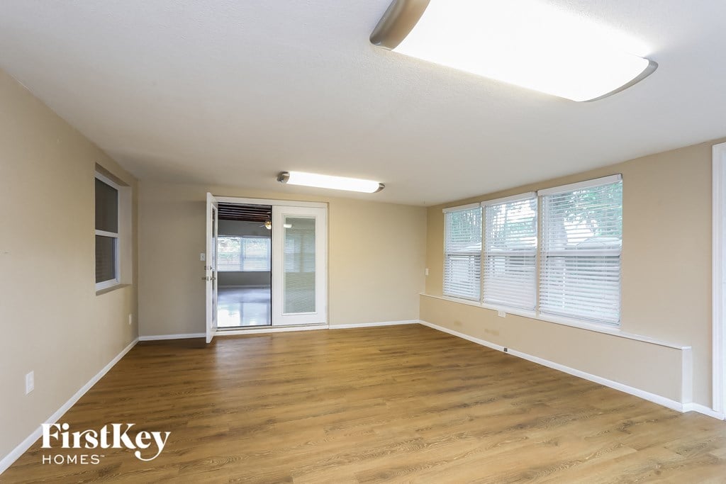 A spacious room with wooden floors and a skylight.
