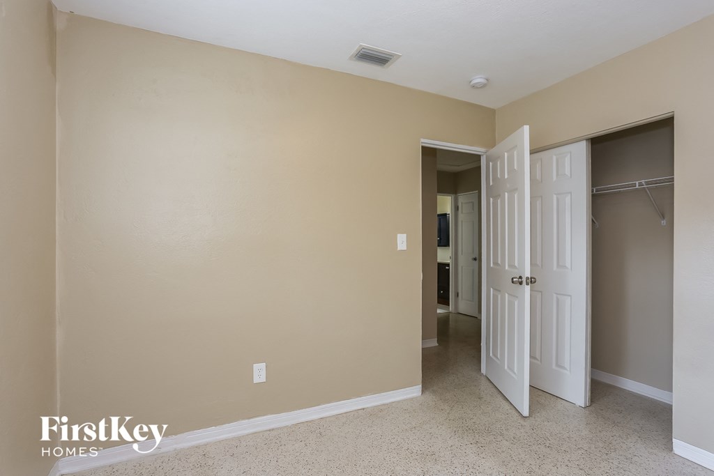 A room with a white door and a carpeted floor.