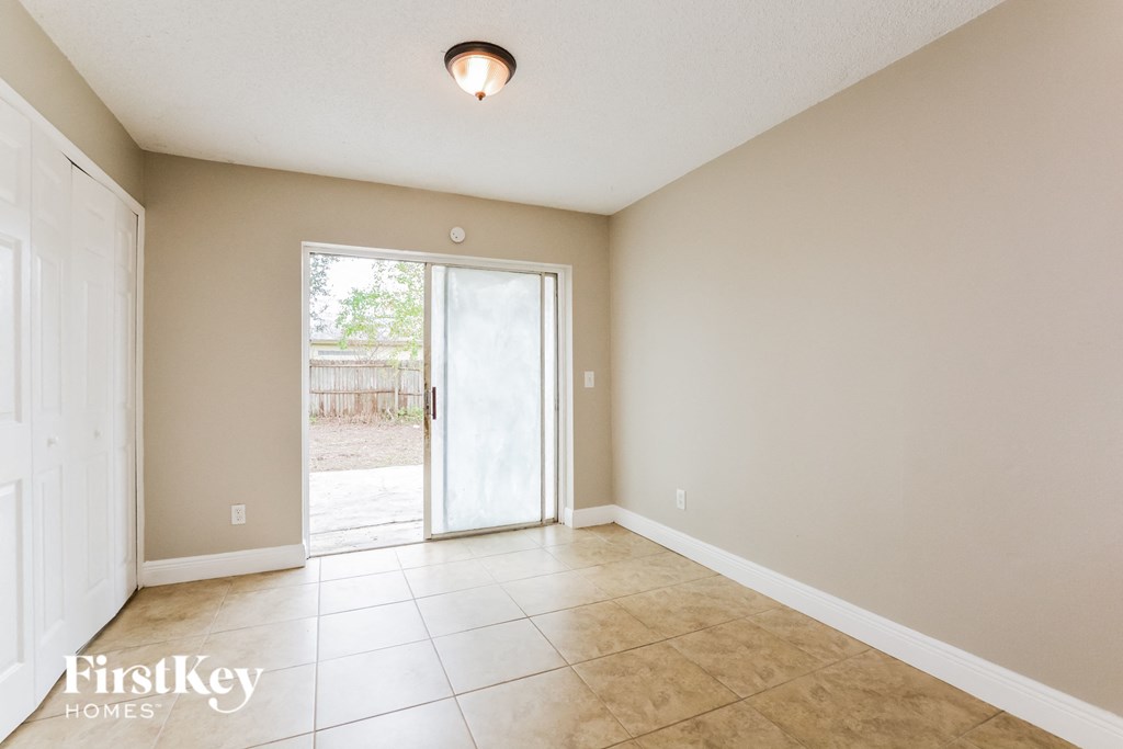 an empty dining room with a sliding glass door to the backyard