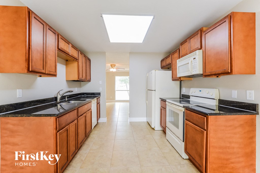 a kitchen with wood cabinets and white appliances and a white refrigerator
