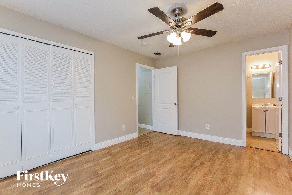 the living room of an empty house with a ceiling fan