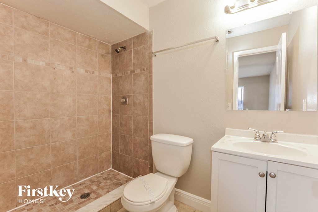 a bathroom with a toilet and a shower and a sink
