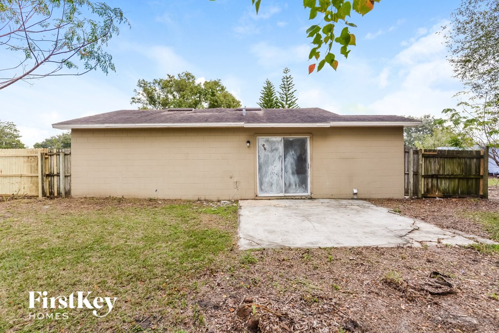 a small tan house with a driveway and a garage door