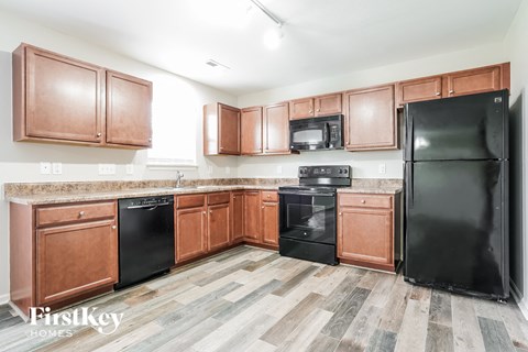 A kitchen with wooden cabinets and black appliances.