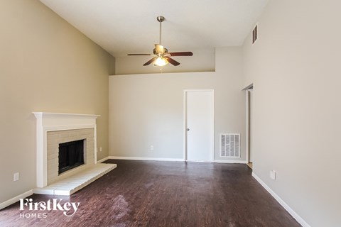 A room with a fireplace and a ceiling fan.
