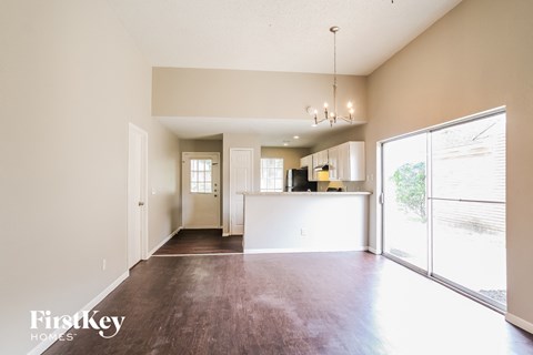 A spacious living room with a view of the backyard through the sliding glass doors.
