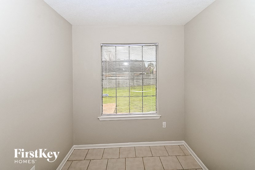 a small room with a window and a tiled floor