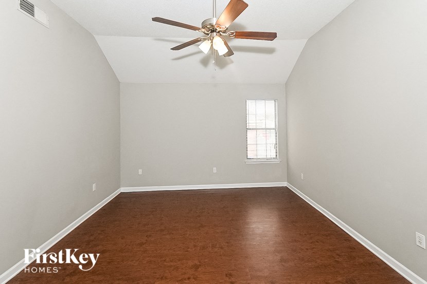 a empty room with a ceiling fan and wood floors