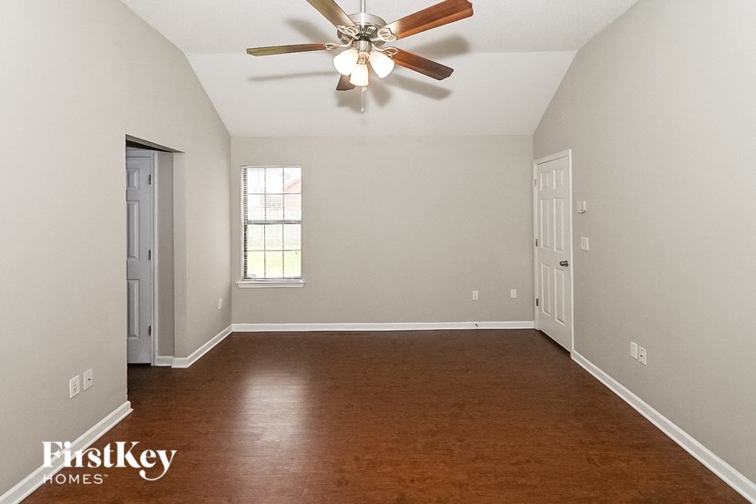 an empty room with a ceiling fan and a door to a closet