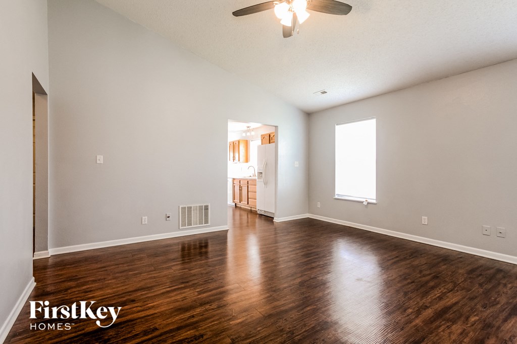 A room with wooden floors and a ceiling fan.