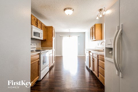 A kitchen with wooden cabinets and a white refrigerator.