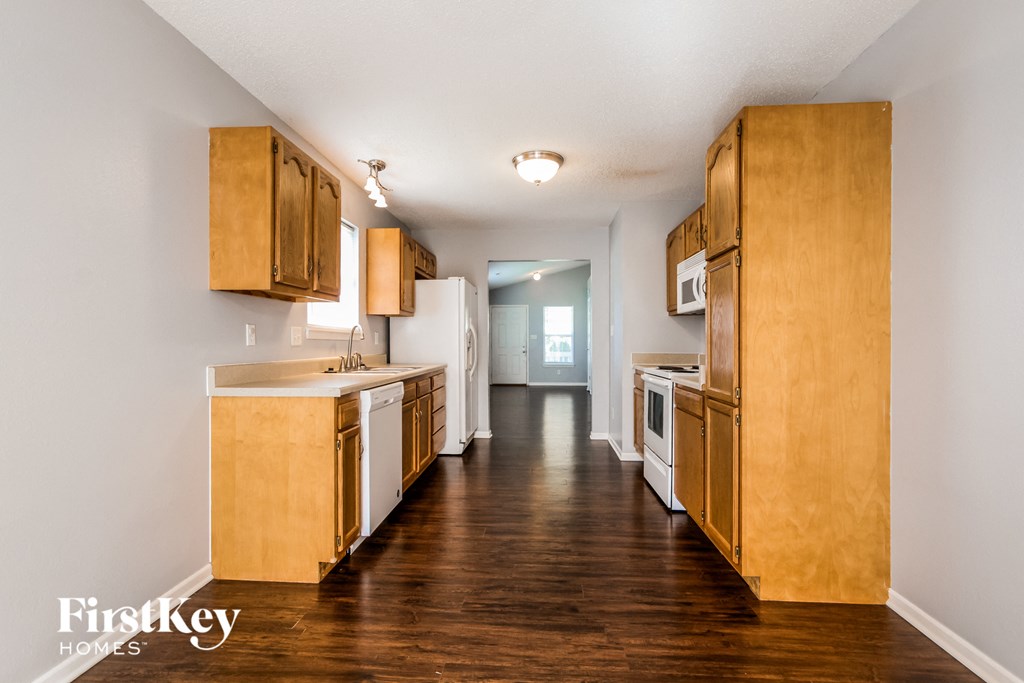 A kitchen with wooden cabinets and a refrigerator in the background.